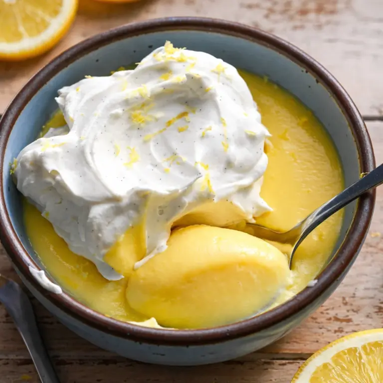 Delicious homemade lemon pudding topped with blueberries and lemon zest.
