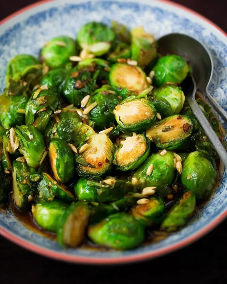 Maple fish sauce brussels sprouts served on a plate, garnished with herbs.