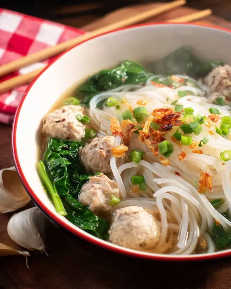 Bowl of Thai Chicken Noodle Soup with fresh herbs and chicken slices