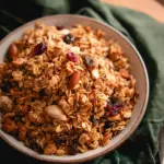Toasted coconut oat granola in a bowl with coconut flakes